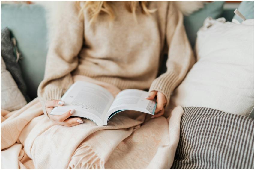 A person with manicured nails enjoys a book while