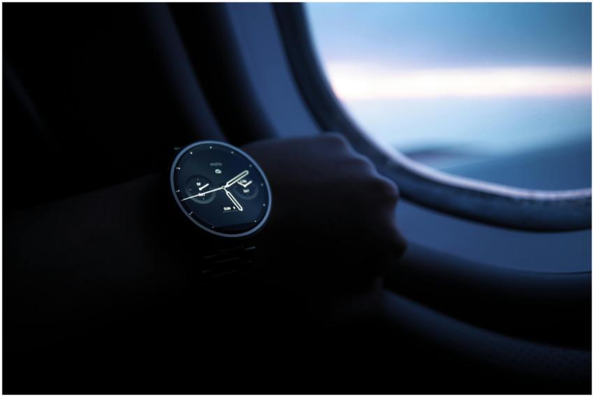 A smartwatch on a wrist shown against an airplane