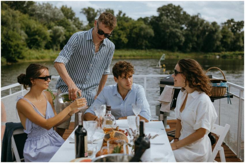 Four friends enjoying a scenic boat dinner party o