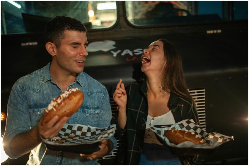 A joyful couple sharing street food at a night mar