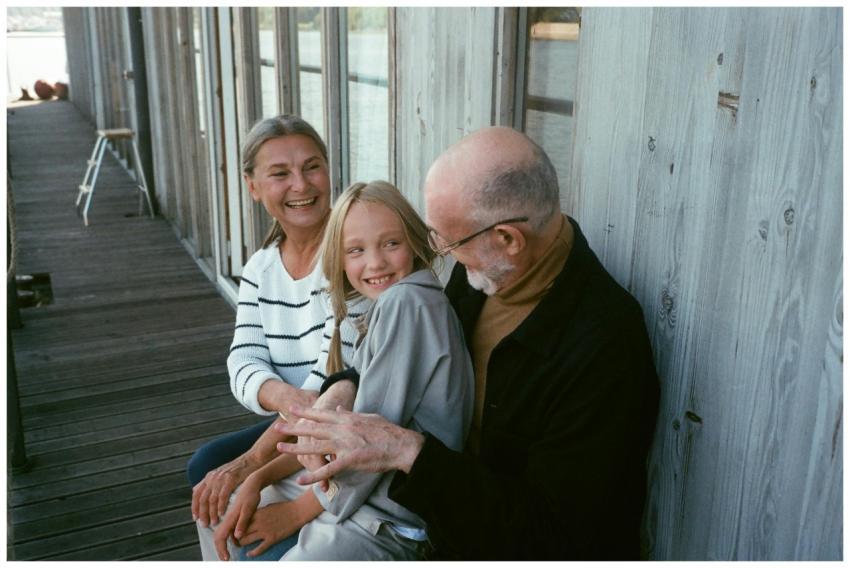 Grandparents and grandchild sitting together, shar