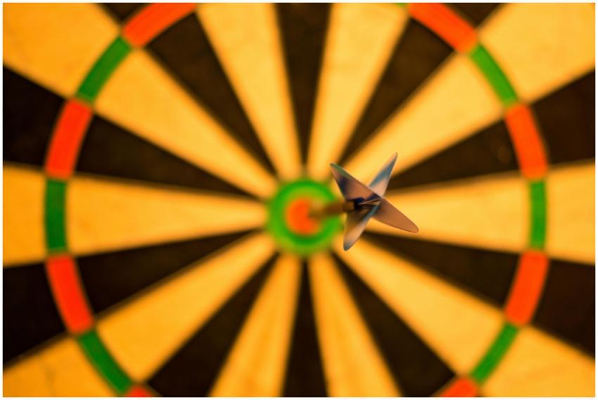 A close-up of a dart perfectly hitting the bullsey