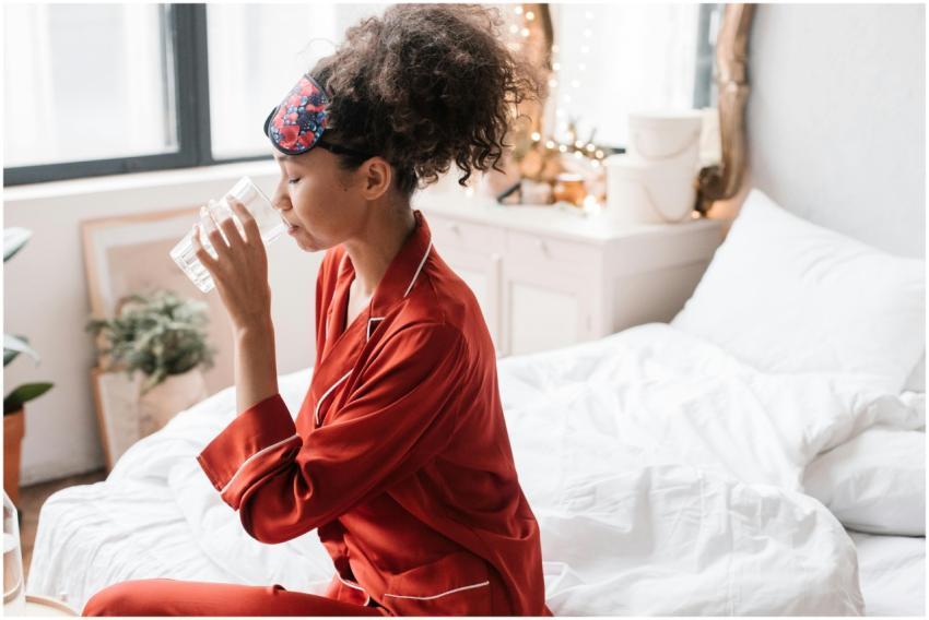 Woman in red pajamas drinking water, enhancing mor