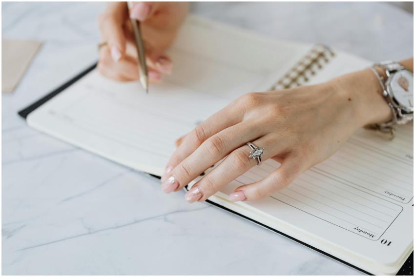 Close-up of hands writing in a notebook, ideal for