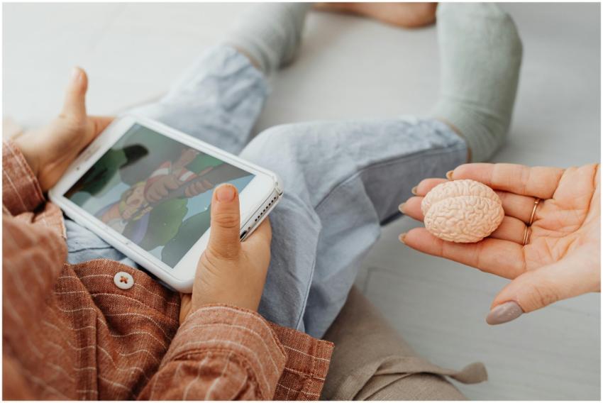 A child watches a cartoon on a tablet as an adult