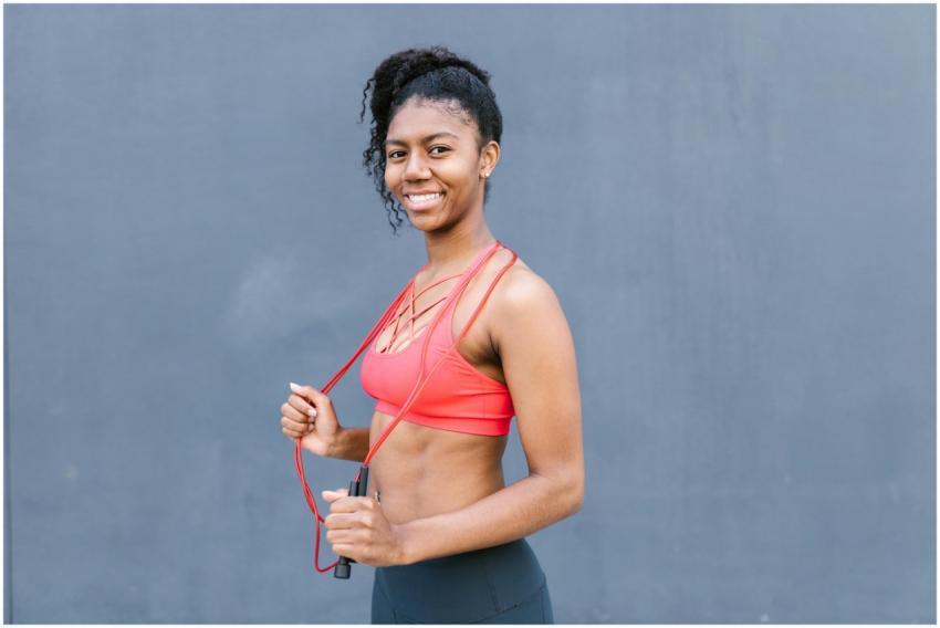 Young woman with curly hair in sportswear holding