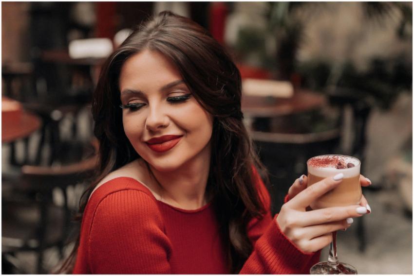 A stylish woman in a red dress savoring a cappucci