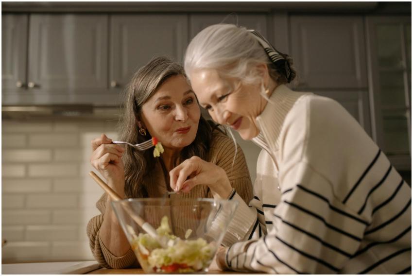 Two senior women smiling and enjoying a fresh sala