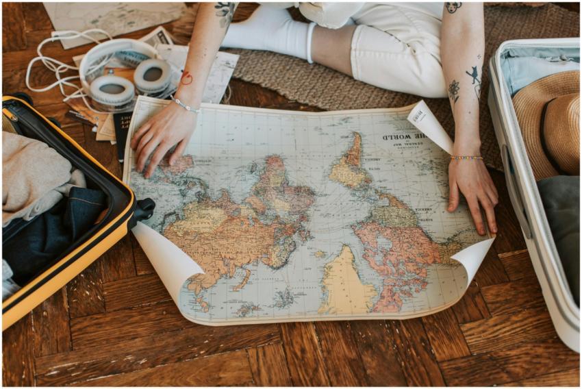 A traveler plans a journey, sitting on the floor w