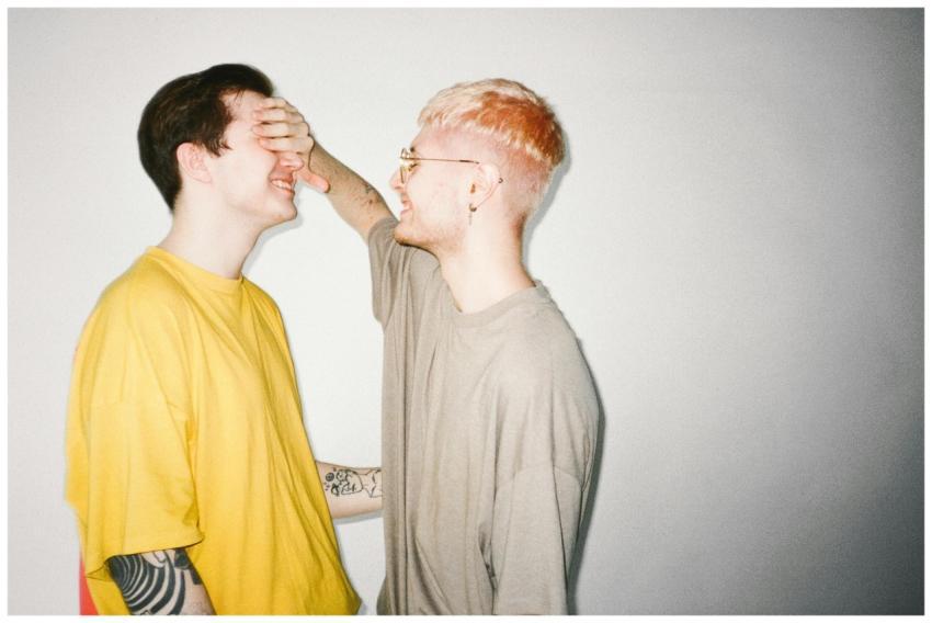 Two men sharing a playful, intimate moment indoors