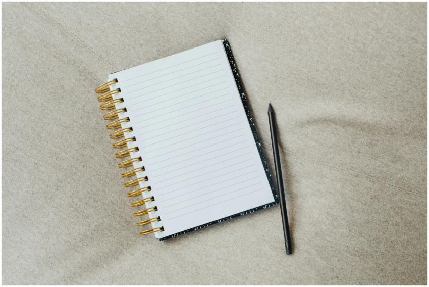 A minimalist notebook with a pencil on fabric surf
