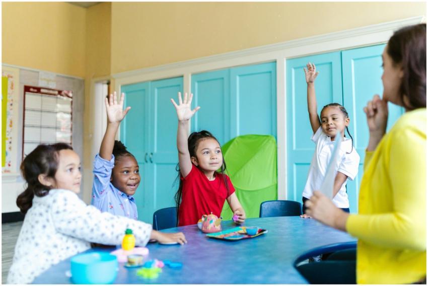 Children eagerly raising hands in a colorful class