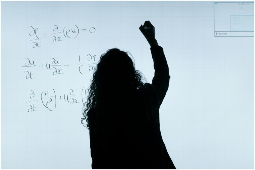 A silhouette of a woman writing mathematical equat