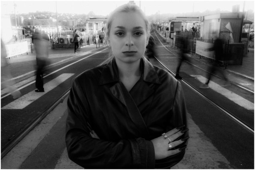 A black and white portrait of a woman in an urban