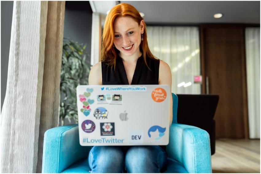 Smiling woman engaged in remote work on a laptop a
