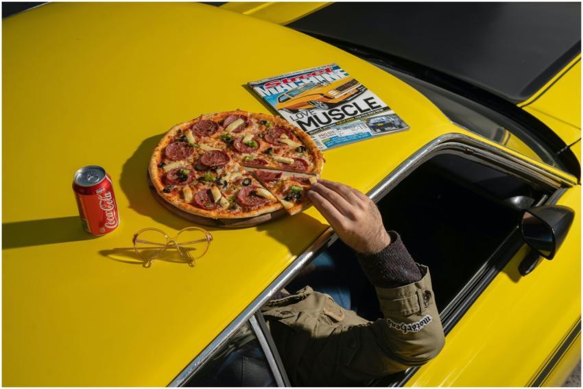 Pizza, cola, and a magazine atop a vintage yellow