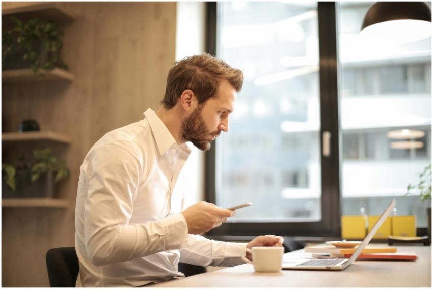 Focused businessman working on laptop while checki