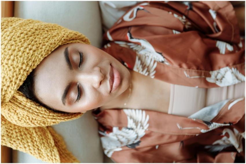 Peaceful woman with closed eyes, wearing a towel a