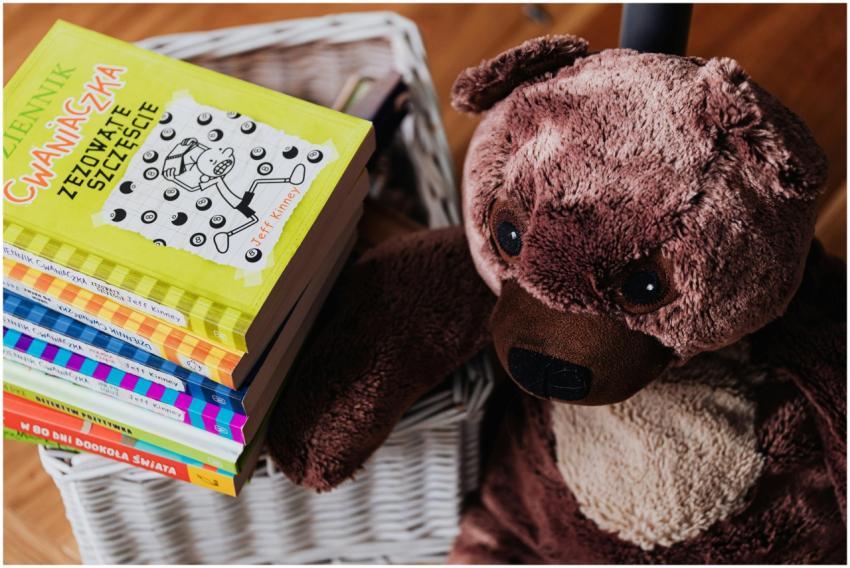 A stack of colorful children's books next to a plu