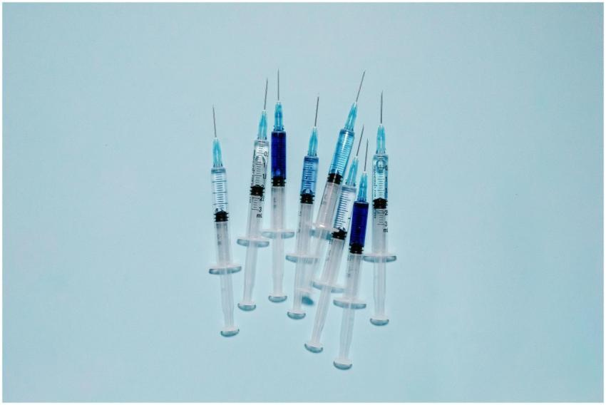 A cluster of medical syringes with blue fluid, ide