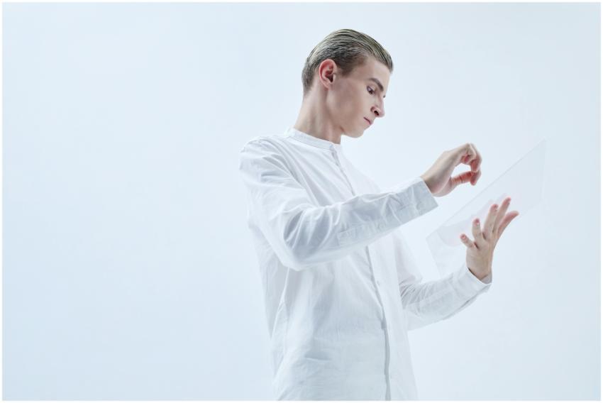 Young man interacting with a transparent digital t