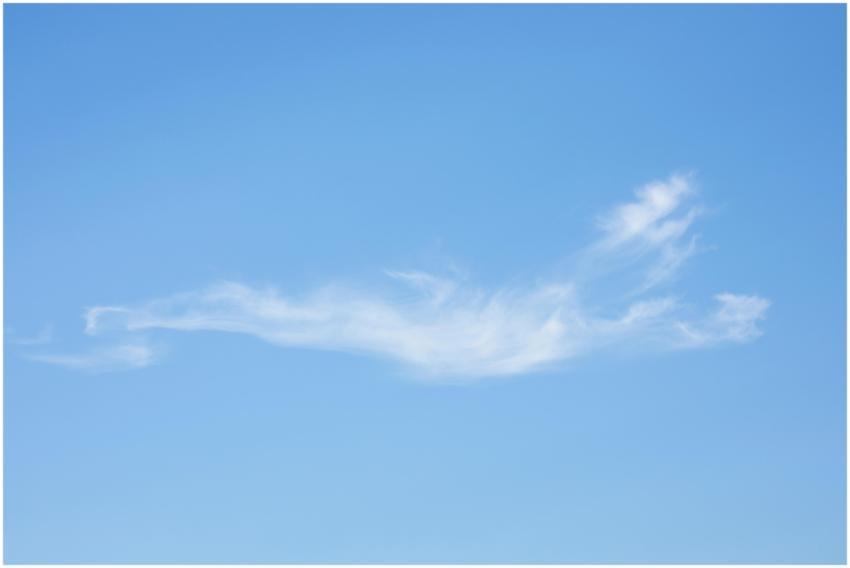 An artistic capture of a single wispy cloud in a v