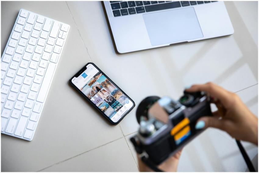 Person using vintage camera with smartphone and la