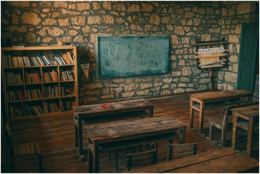 An empty rustic classroom featuring stone walls, w