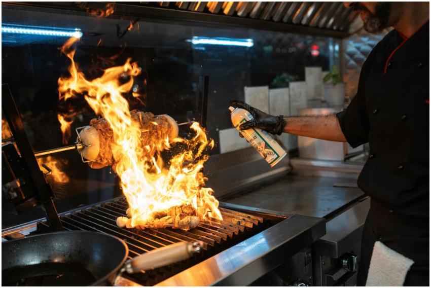 Chef uses a culinary torch to ignite a flaming gri