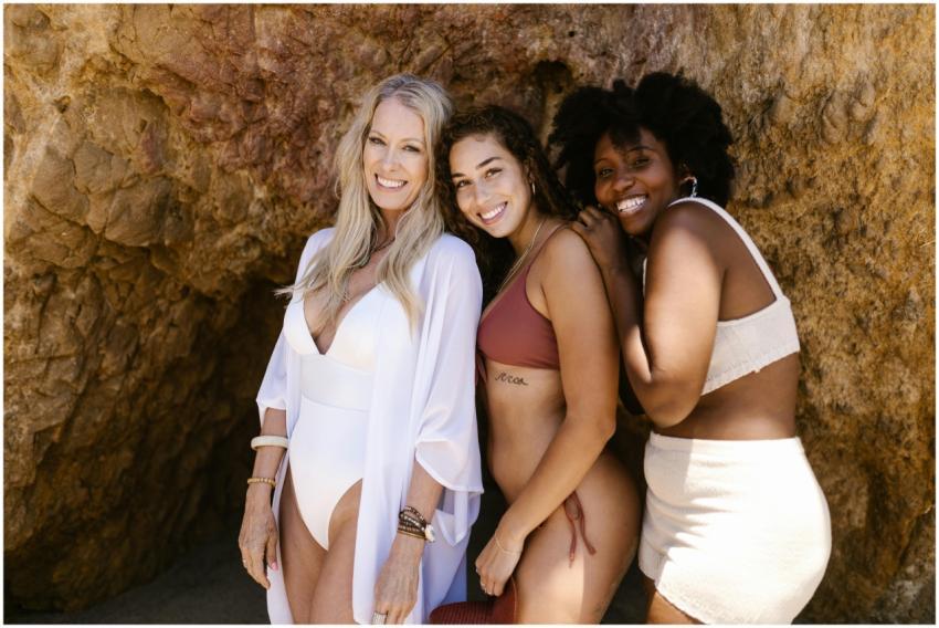 Three diverse women smiling and enjoying a sunny b
