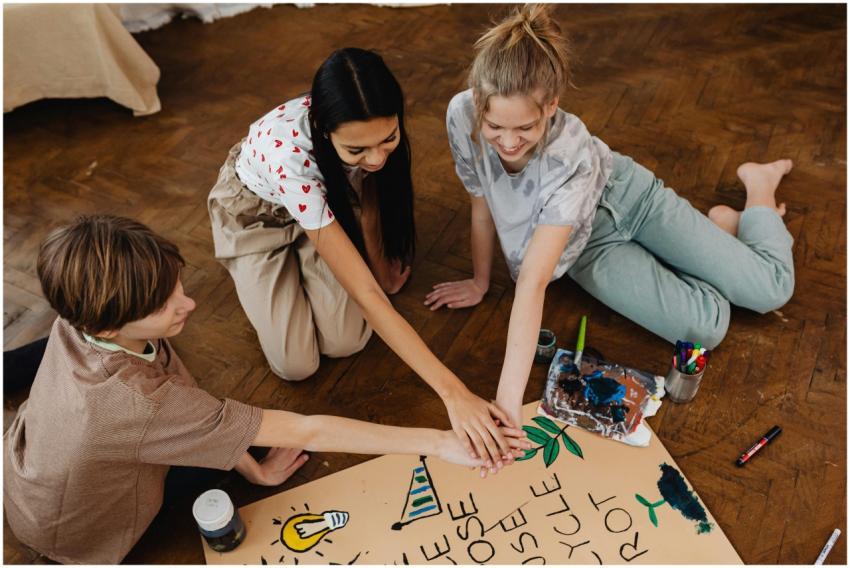 Three teenagers work together on an artistic proje