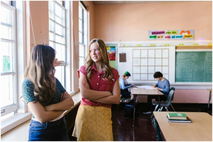 Two students engaged in conversation by the classr