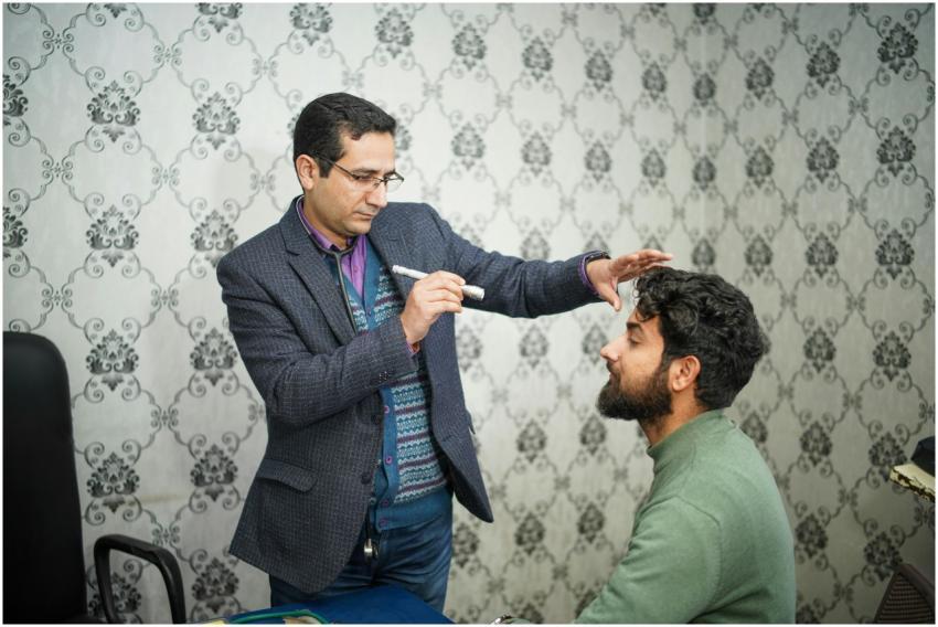 A doctor performs an eye examination on a patient