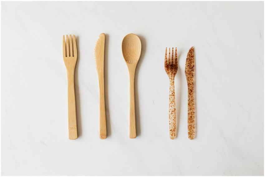 Top view of wooden and plastic cutlery placed in r