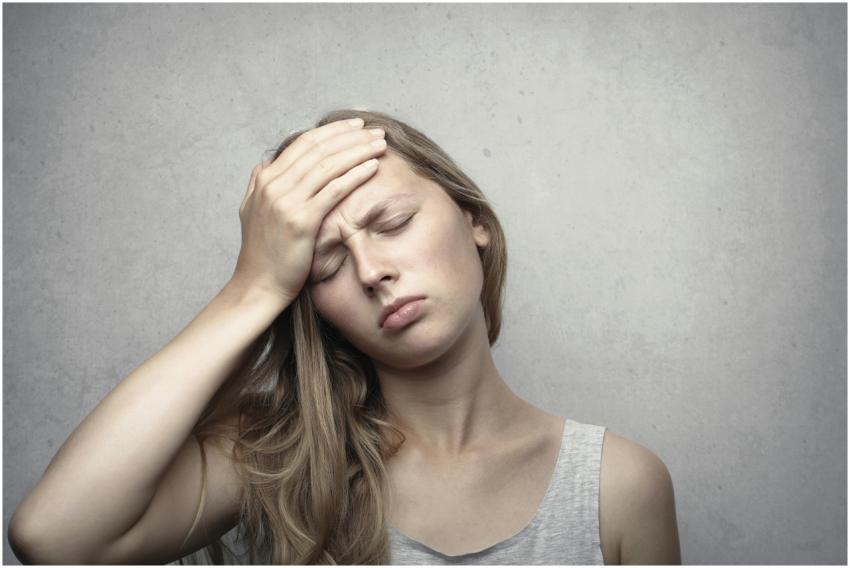 A woman in distress holding her head, expressing e