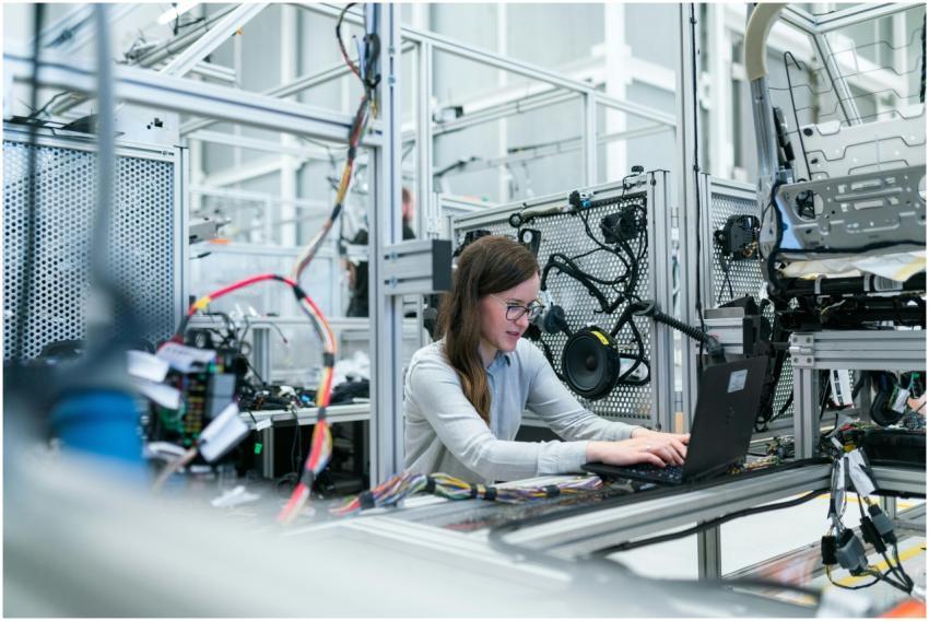 A female engineer focuses on her laptop amidst adv