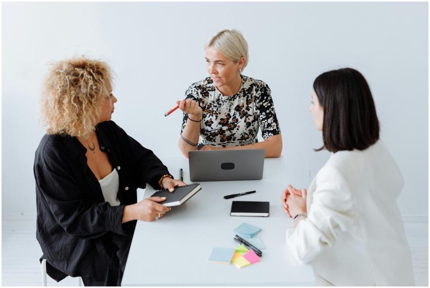 Three professional women discussing ideas around a