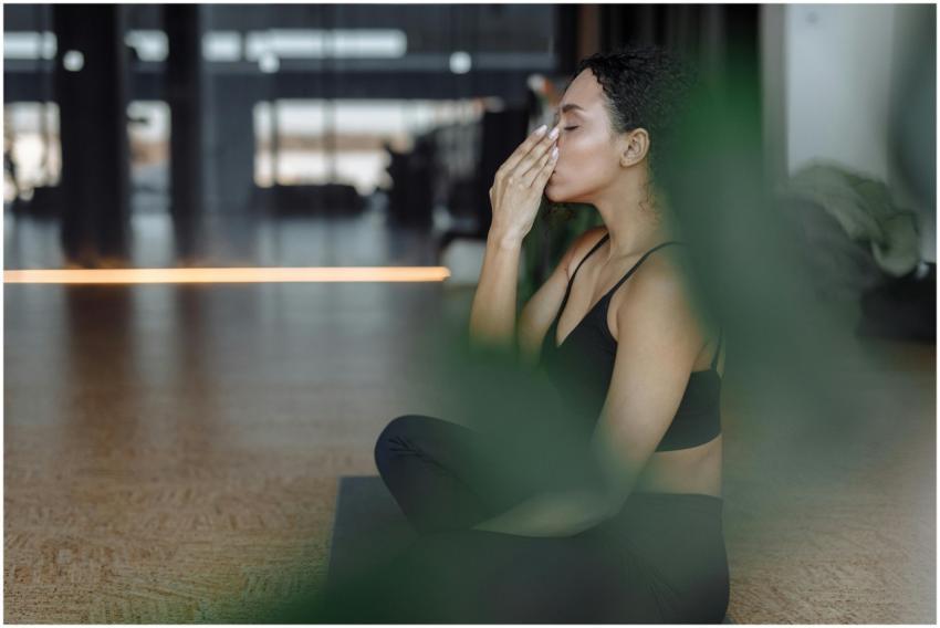 Peaceful woman practicing yoga indoors with eyes c
