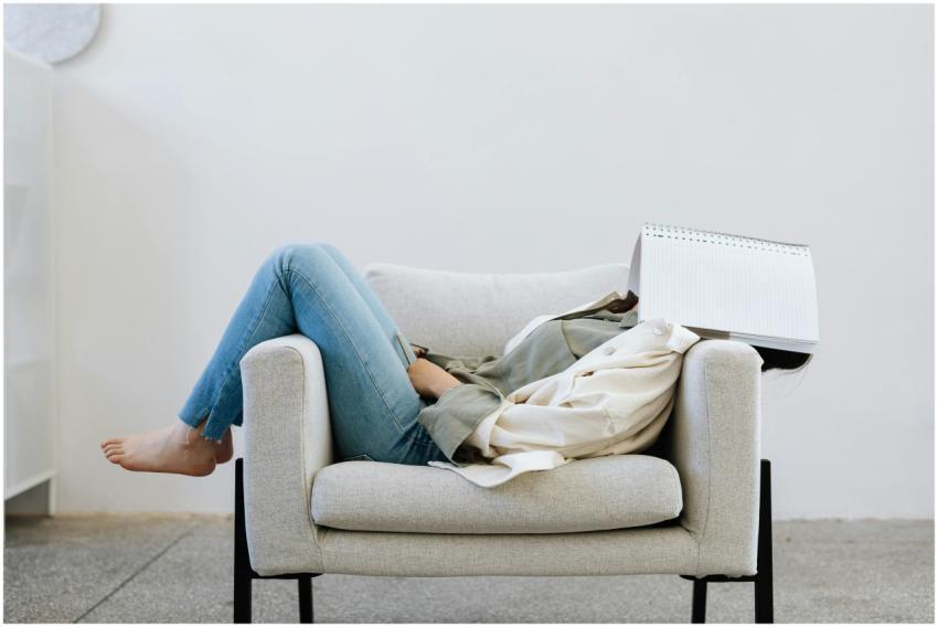 Woman lounging indoors on a chair with a notebook