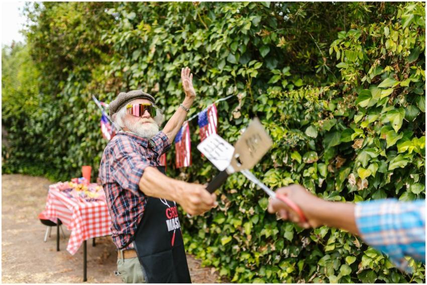 Elderly man enjoying a lively backyard barbecue wi