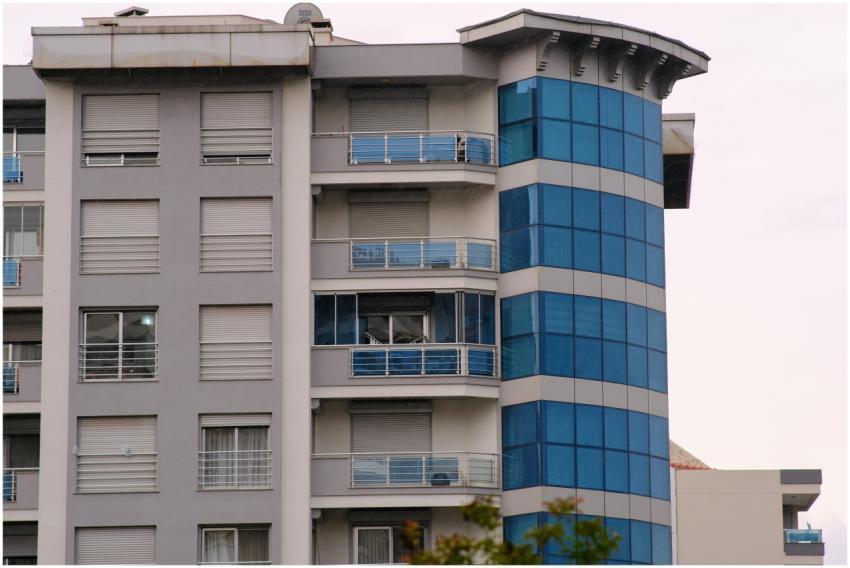 Contemporary apartment building facade with blue g
