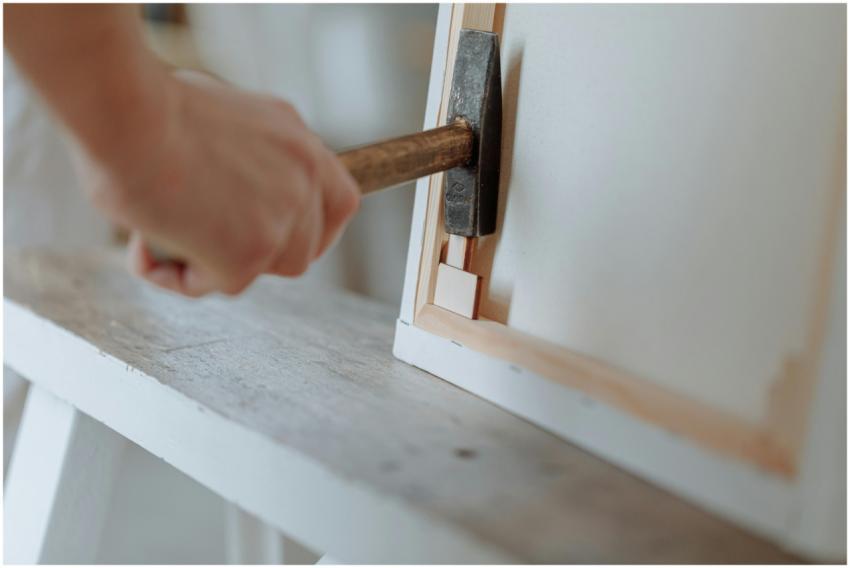 Detailed image of a hand using a hammer to work on