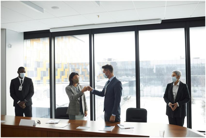Diverse professionals in formal attire fist bumpin