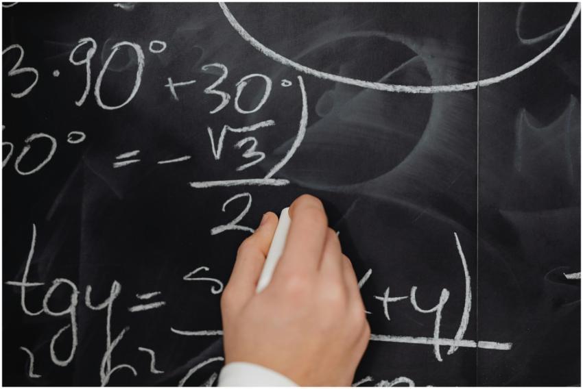 A hand vividly writing complex mathematical equati