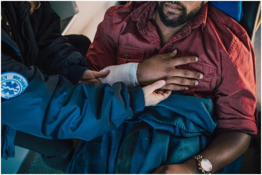 Paramedic assisting injured patient with arm banda