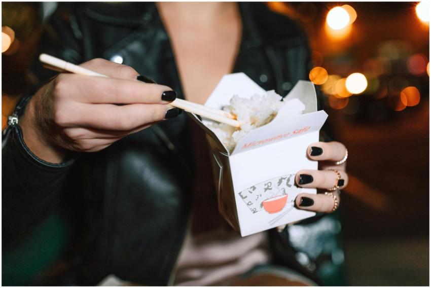 Close-up of a woman eating rice with chopsticks fr