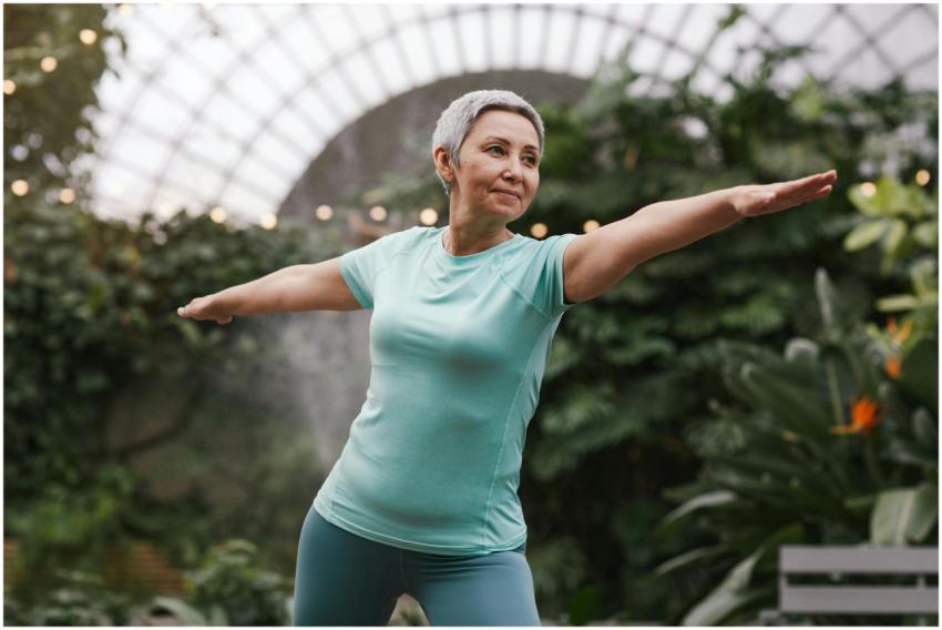 Elderly woman performing a yoga warrior pose in a