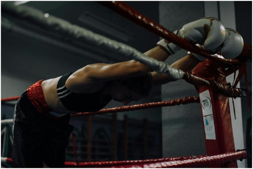 A dedicated female boxer rests in the ring, showca