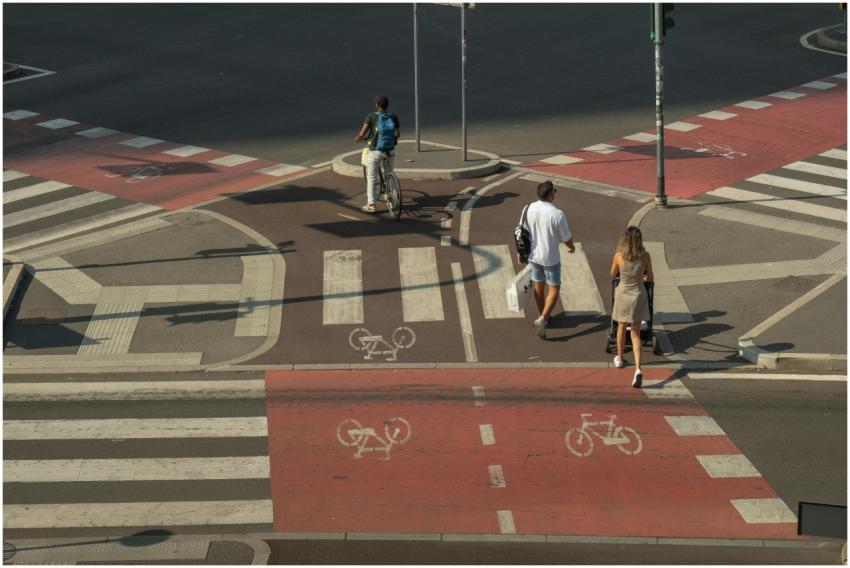 A cyclist and pedestrians crossing a city intersec