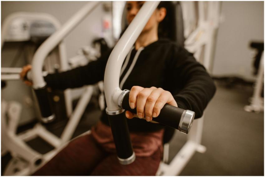 Close-up of a woman using a chest press machine in